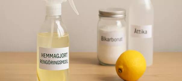 "Sprayflaska med hemmagjort rengöringsmedel av ättika, citron och bikarbonat – symboliserar naturlig och miljövänlig rengöring med hemmagjorda ingredienser"